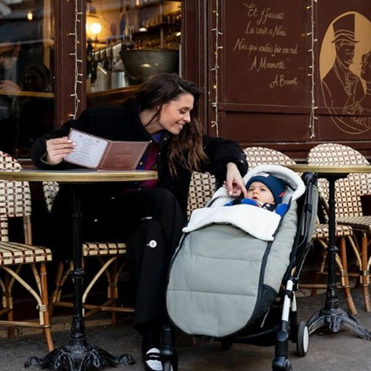 Maman en terrasse avec bébé dans chancelière poussette gris