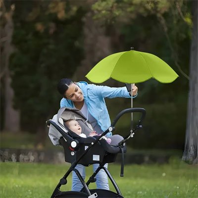 Maman et bébé au parc sous ombrelle pour poussette vert