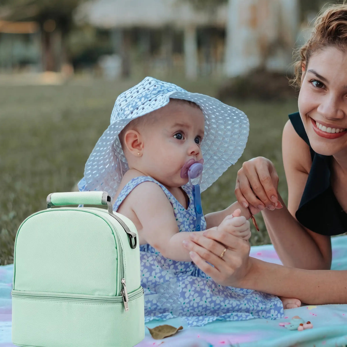 Maman et bébé dehors avec porte biberon vert pratique