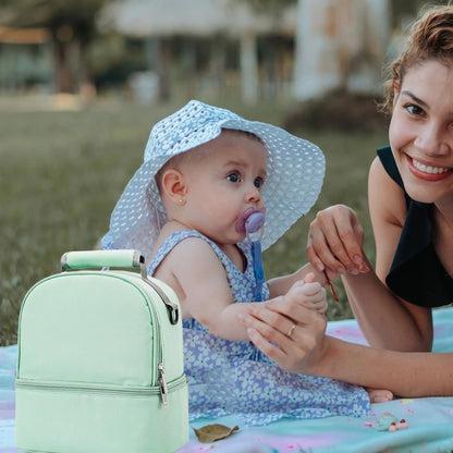 Maman et bébé dehors avec porte biberon vert pratique