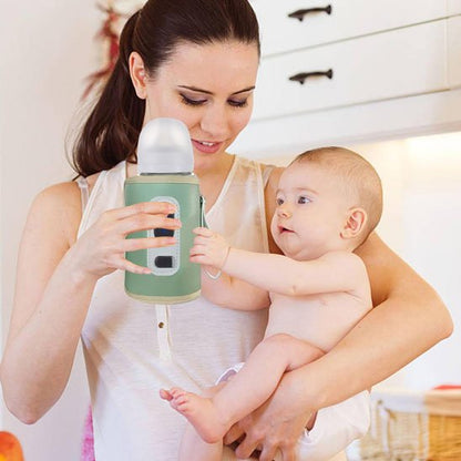 Maman et bébé tiennent chauffe biberon vert