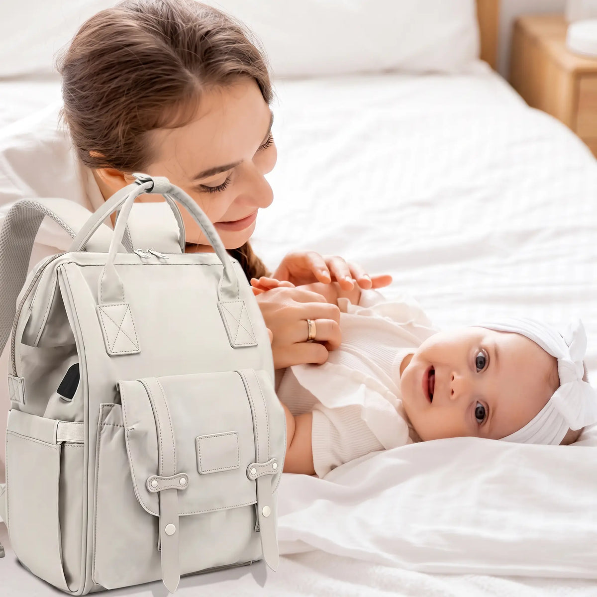 Maman joue avec bébé couché sac langer blanc à côté