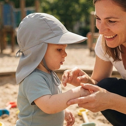 Maman joue avec bébé  portant casquette pour bebe