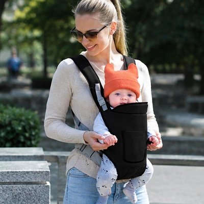 Maman marche avec bébé dans porte bébé noir