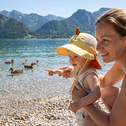 Maman à plage avec bébé portant chapeau bebe jaune