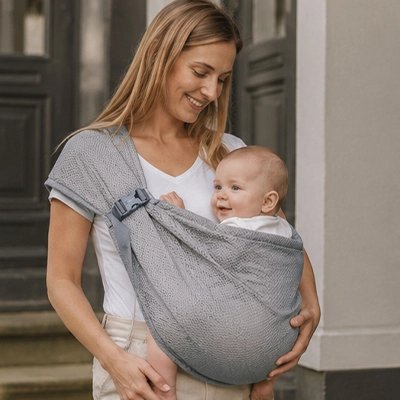 Maman porte bébé dans echarpe de portage gris