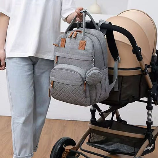 maman près sac à langer gris accroché à poussette