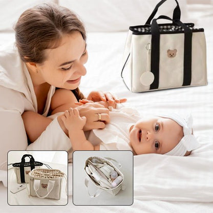 maman rit avec bébé près sac à langer blanc doudou