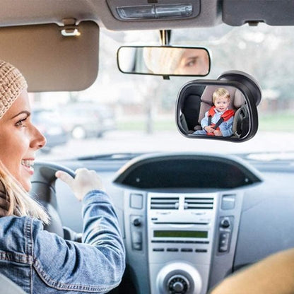 Maman souriante voit bébé à travers miroir voiture bébé