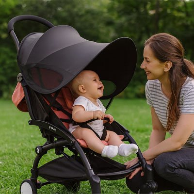 Maman sourit à bébé sous par soleil pour poussette​ 