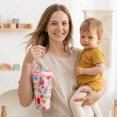 Maman tient bébé avec porte biberon rose fruit
