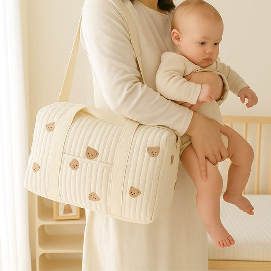 maman tient bébé avec sac à langer beige ourson à épaule