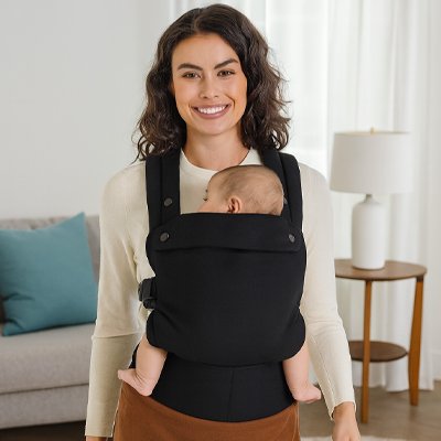 maman tient bébé contre elle dans porte bébé noir