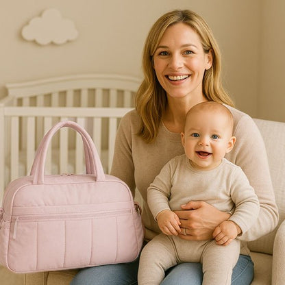 Maman tient bébé près de sac à langer rose