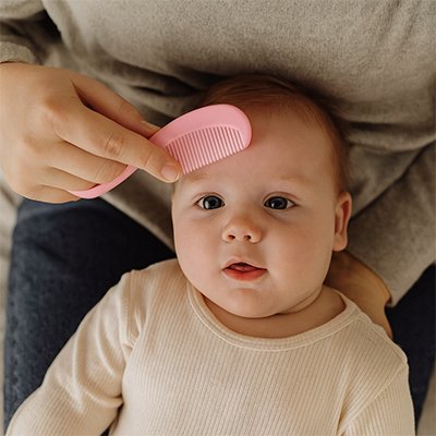 Maman utilise peigne rose trousse de toilette bebe 