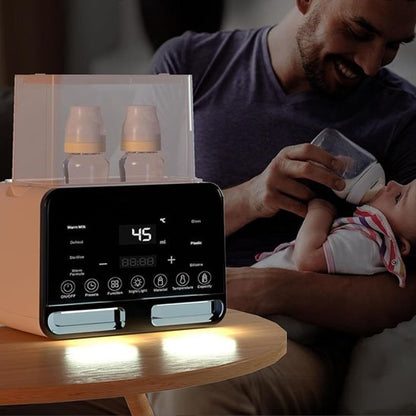 Papa- assise-sur-lit-tient bébé  près de chauffe biberon 