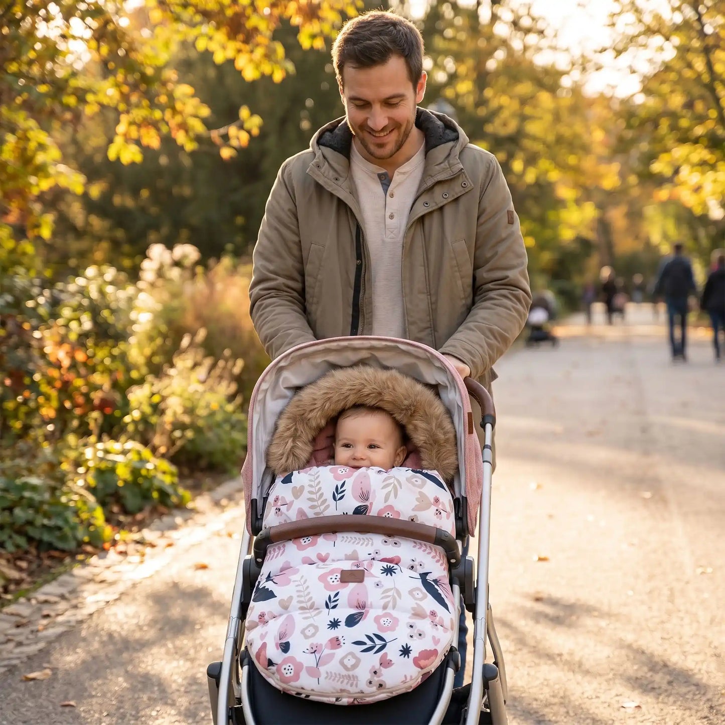 Papa au parc avec bébé dans chancelière poussette fleural