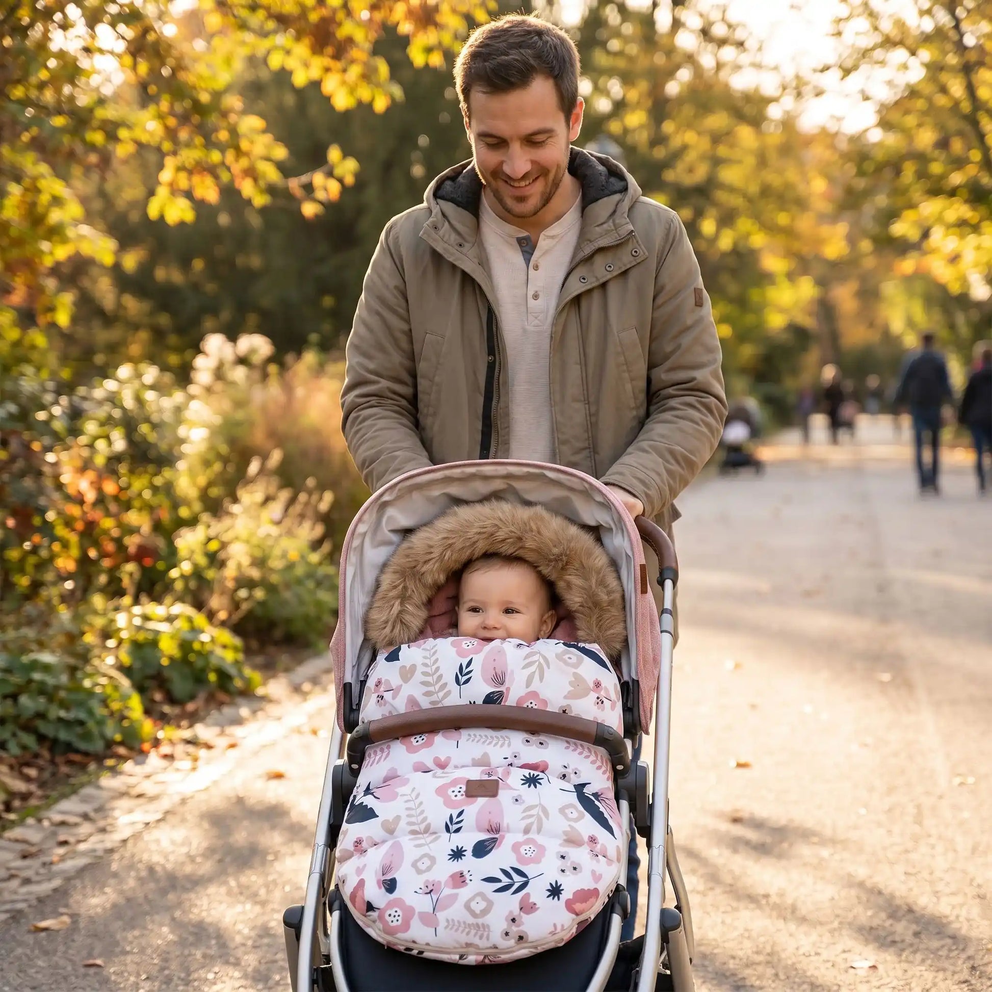 Papa au parc avec bébé dans chancelière poussette fleural