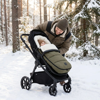 Papa avec bébé dans chancelière vert olive  dans les bois