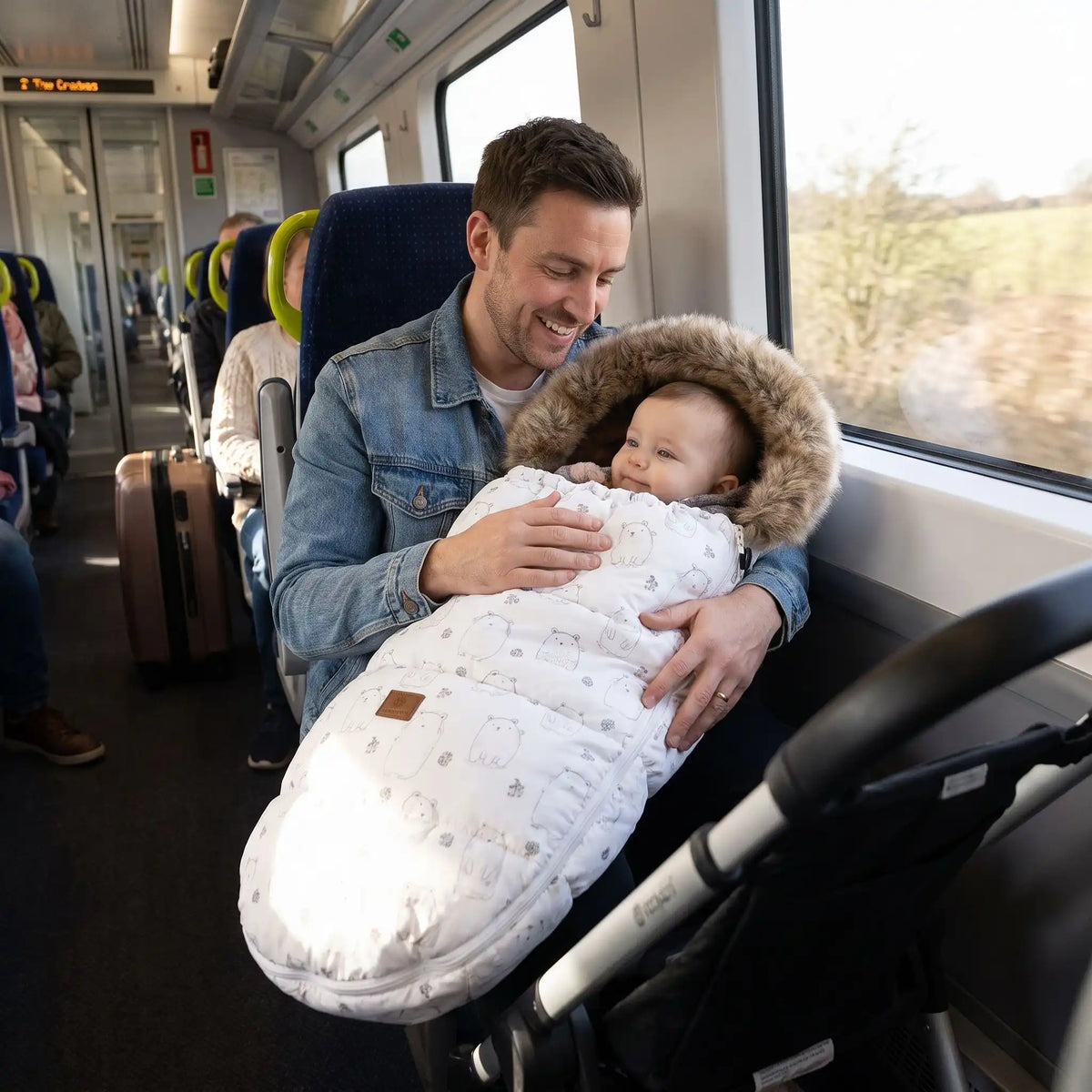 Papa en train avec bébé dans chancelière poussette beige ours