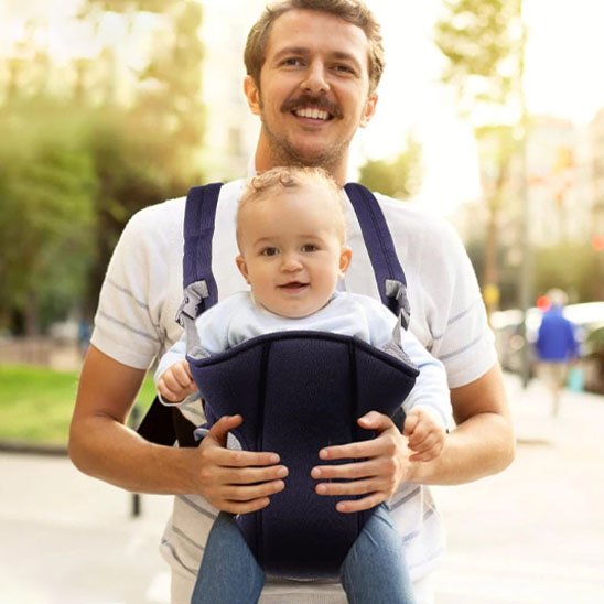 Papa joyeux avec bébé dans porte bébé bleu nuit