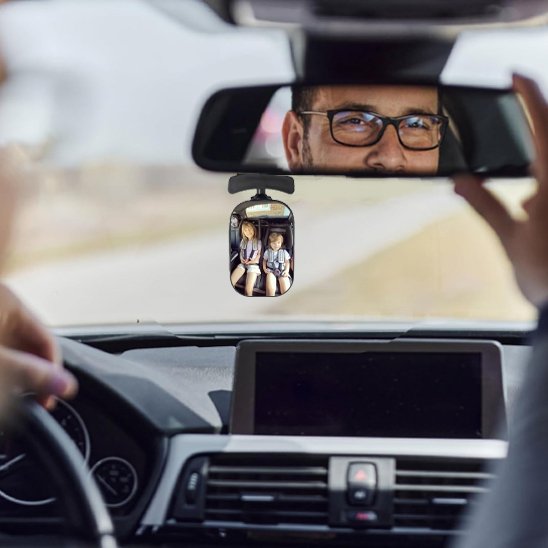 Papa regarde à travers miroir voiture bébé