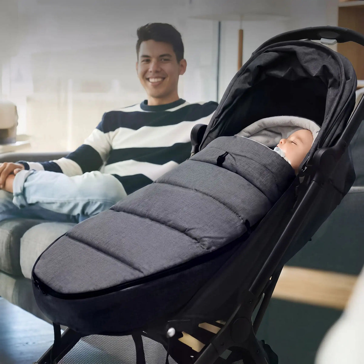 Papa souriant avec bébé dans chancelière poussette