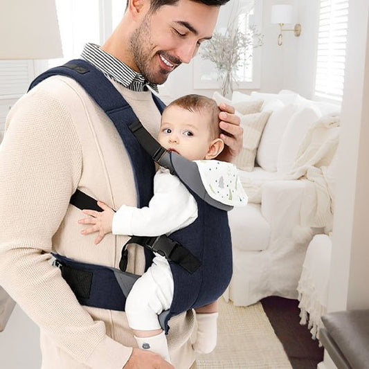 papa tient contre lui bébé dans porte bébé bleu nuit