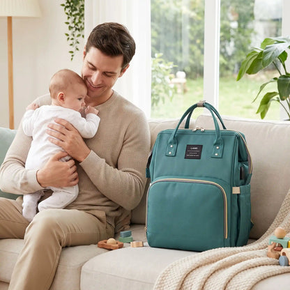 Sac a langer pliable vert près papa portant bébé