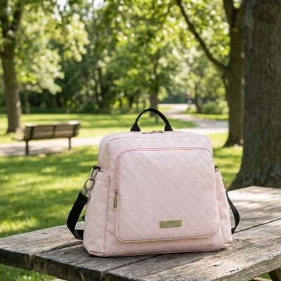 Sac à langer bebe rose exposé sur banc au parc