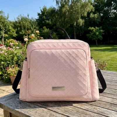 Sac à langer bebe rose posé sur table au parc