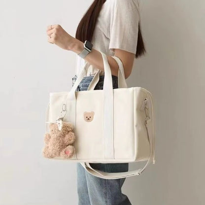 sac à langer blanc doudou accroché au bras de maman