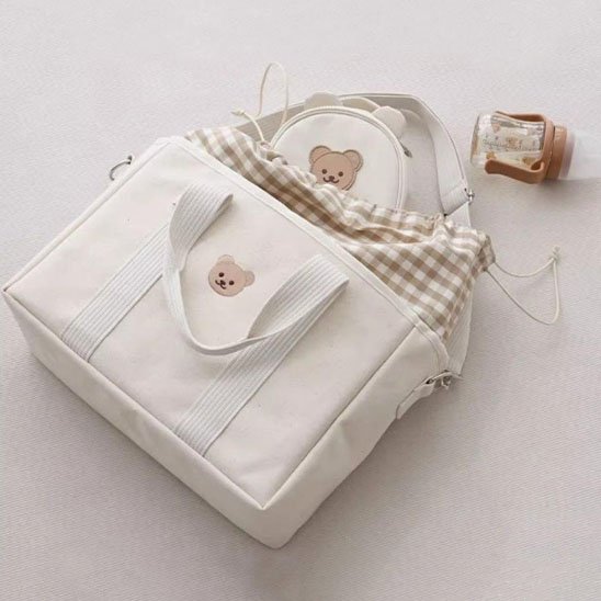 sac à langer blanc doudou sur table blanche
