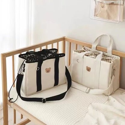 sac à langer blanc et  noir doudou exposés  dans berceau