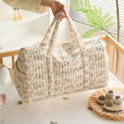 sac à langer fleuri dans berceau à côté chausson