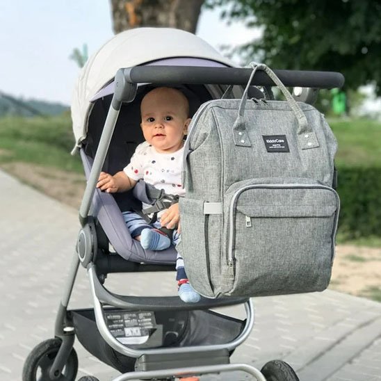 Sac à langer gris jean accroché à poussette