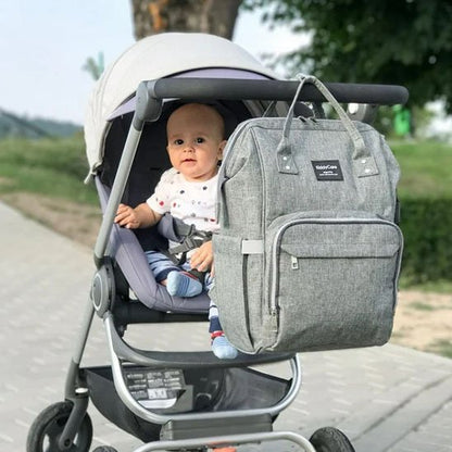 Sac à langer gris jean accroché à poussette