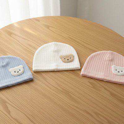 trois bonnet bébé  bleu blanc rose ourson sur tabla