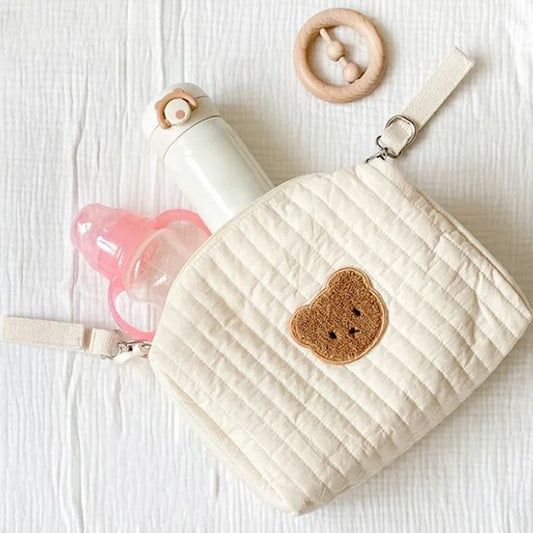 Trousse de toilette bebe ouverte posée sur lit